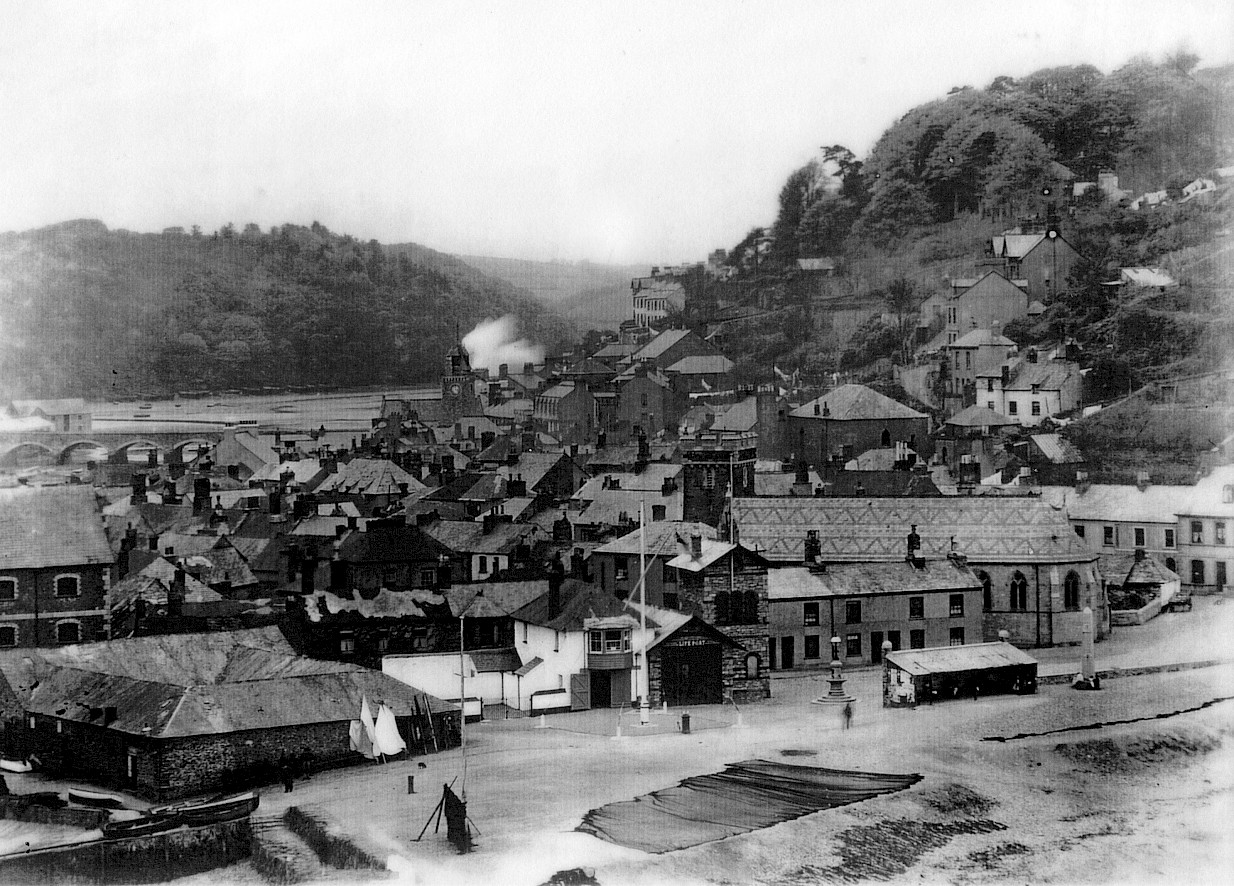 Long shot of lifeboat house with town and hills in background