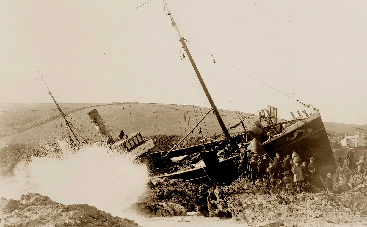 Wreck of the Marguerite with wave crashing against rocks in foreground